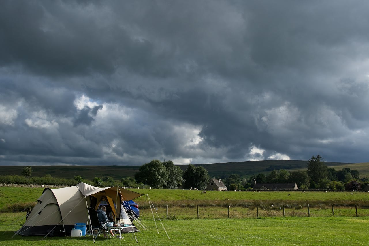 A campsite in Bellingham, England with dark clouds looming overhead, depicting an impending storm.